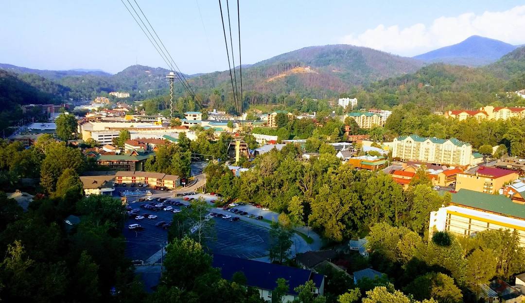 Photo of Ober Mountain ski resort in Gatlinburg, Tennessee, showcasing a charming challet, a ski lift leading up the mountain, all under a bright, sunny sky.