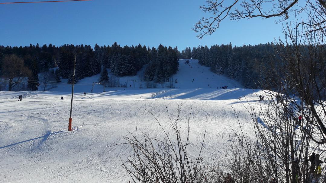 Winter sports scene at the ski resort in Tramelan, Bernese Jura, Switzerland, featuring a charming chalet amidst stunning winter scenery.