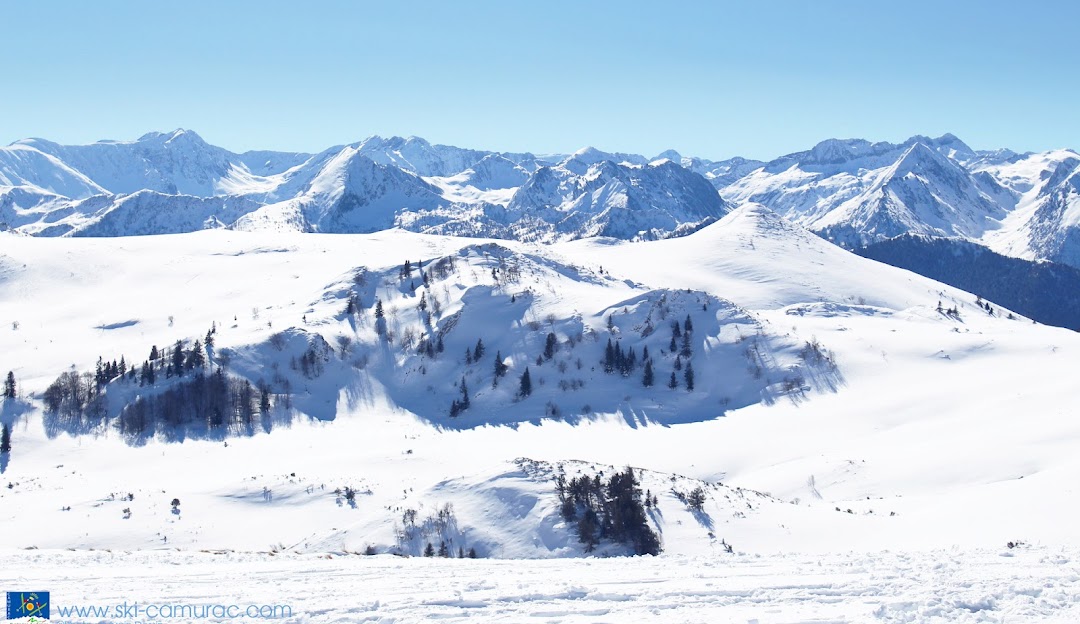 Ski resort in Camurac, Ariège, with snow-covered slopes. Visible winter sports activities and a charming challet amidst stunning winter scenery.