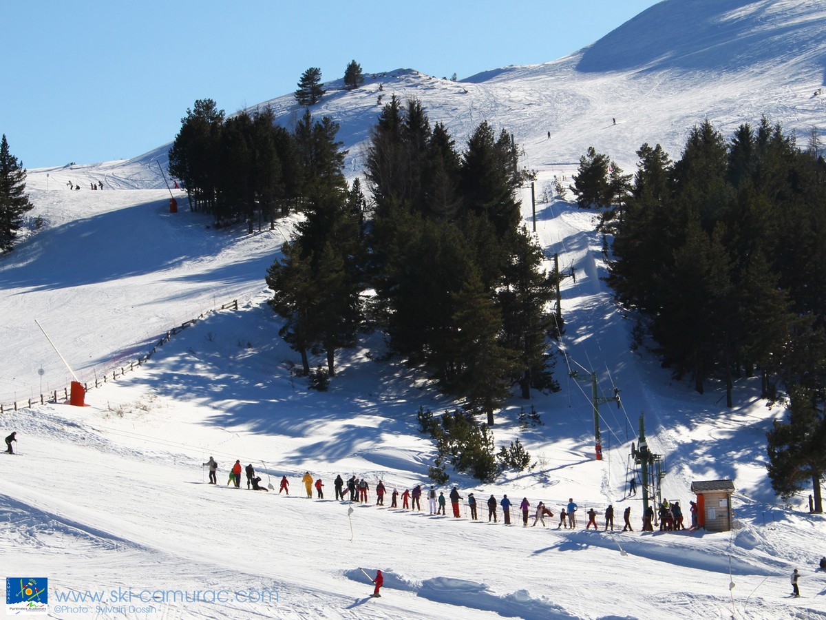 Camurac in France - a group of people skiing down a snowy slope.