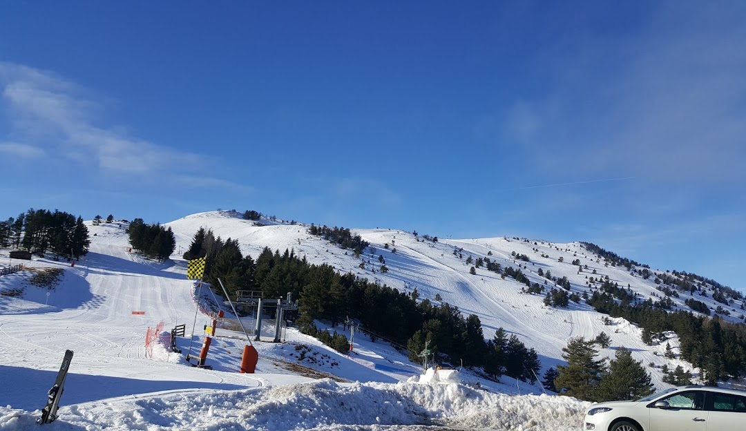 A cozy challet is captured in the winter sports scene at the ski resort in Camurac Ariège France. Skiers enjoy the pristine slopes serviced by a ski lift in this charming winter sports centre.