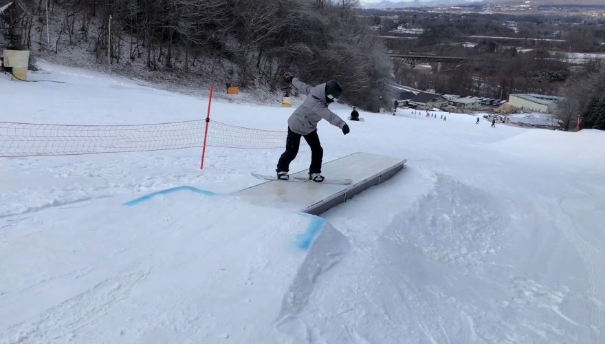 A snowboarder gliding down the powdery slopes of Saku Ski Garden Parada in Nagano Japan on a brilliant winter day.