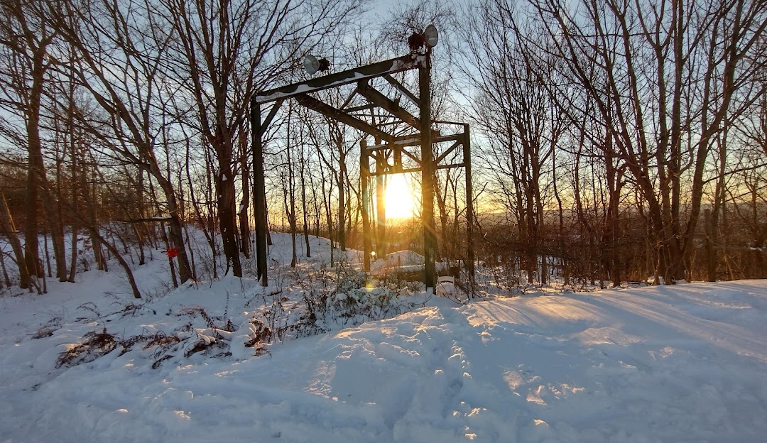 Winter sports enthusiasts enjoy a stunning day at Powder Ridge Mountain Park & Resort in Middlefield, Connecticut. The landscape is enveloped in snow, with the ski lift discernible in the midst of this winter wonderland.