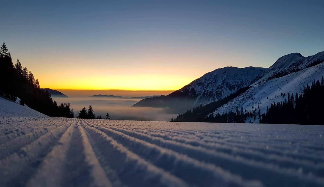 Winter sports enthusiasts enjoy a day at the ski resort in Niederalpl, Styria, Austria, framed by stunning winter scenery and majestic mountains.