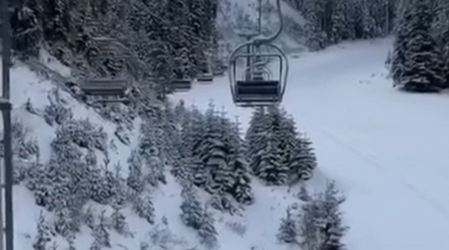 Ski lift ascending the snow-covered slopes of Yıldıztepe ski resort in Central Anatolia, Turkey. A chalet nestles amidst the winter backdrop, creating a picturesque winter sports scene.
