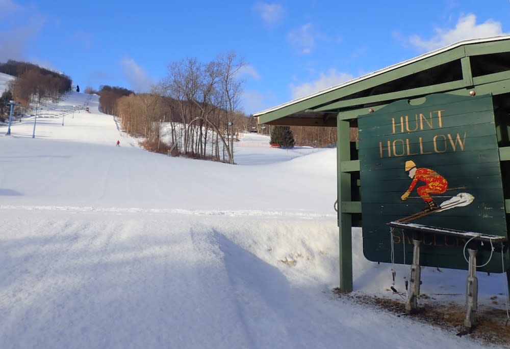 Hunt Hollow Ski Club in USA - a snow covered ski slope with a sign on it.