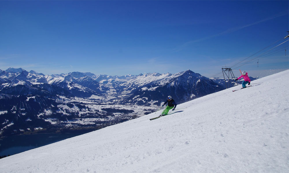 A skier cruises down a snow-covered slope in Beatenberg-Niederhorn a ski resort in Switzerland's Bernese Oberland. A charming chalet peeks through the winter sports scene.