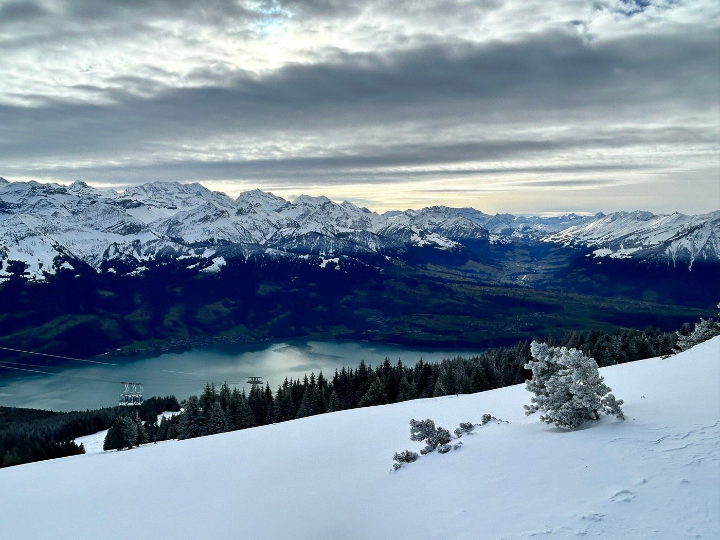 A scenic view in Beatenberg-Niederhorn, Switzerland showcasing a winter sports scene at a ski resort with an inviting chalet nestled among snowy peaks.
