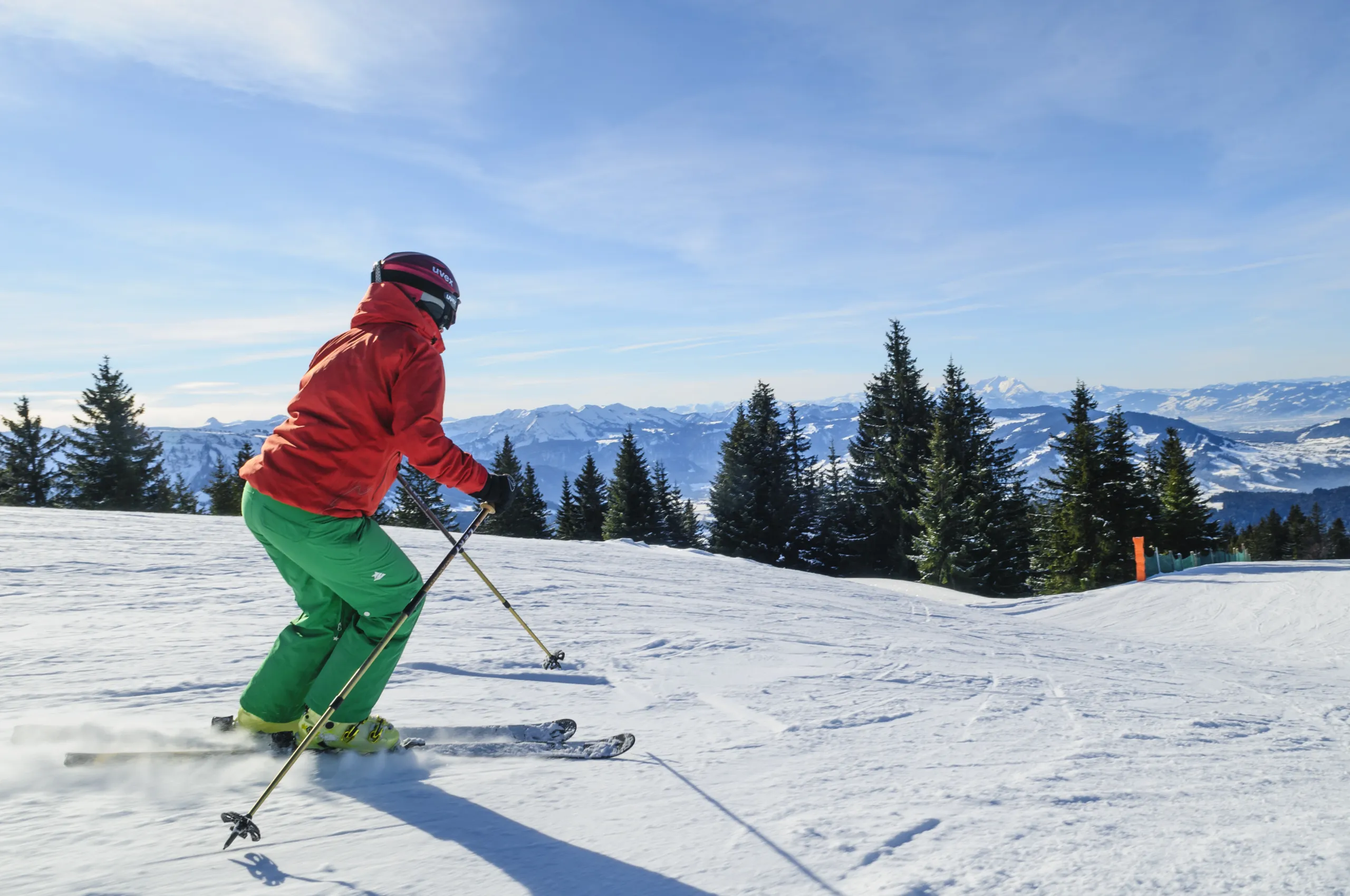 A skier navigates a snowy slope at the Hochhäderich ski resort in Austria a ski lift visible in the background. The scene featuring a quaint chalet encapsulates a classic winter sports experience.