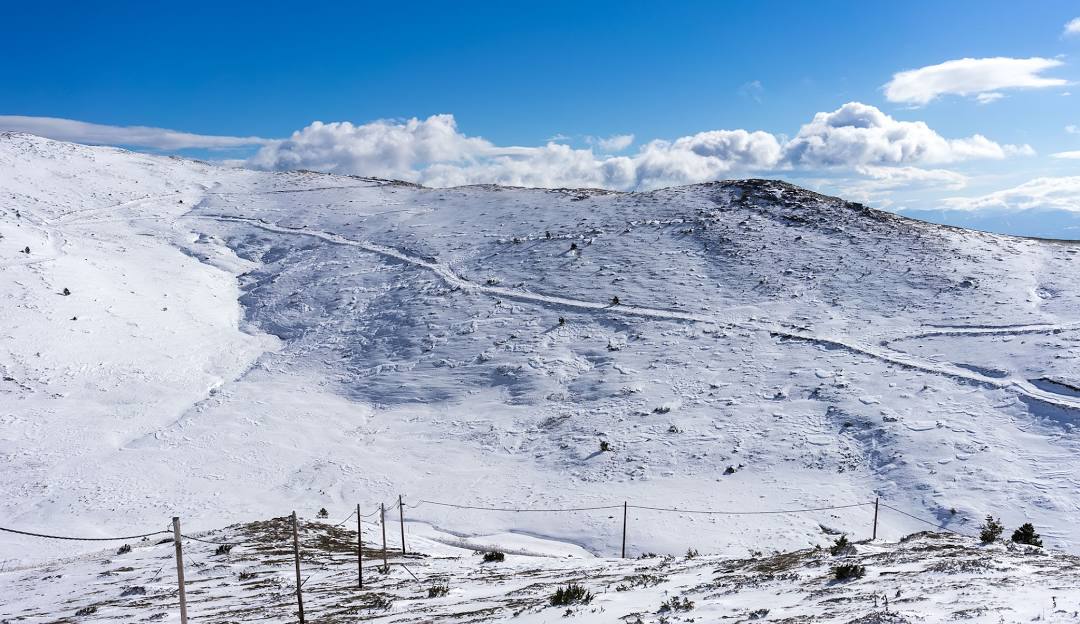 A winter sports scene at Voras-Kaimaktsalan in Edessa Greece featuring snow-covered slopes a winter sports centre a chalet and a snowy mountain.