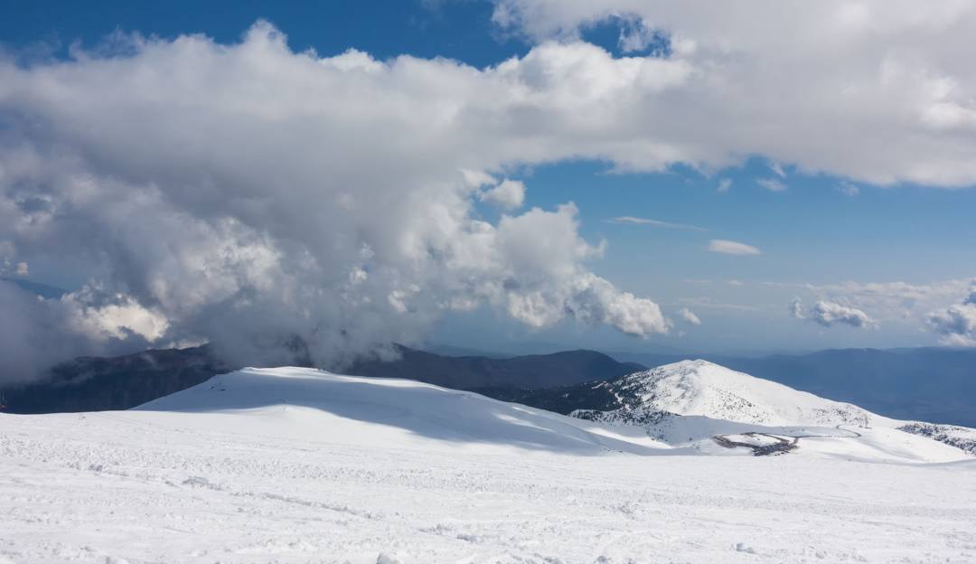 Breathtaking winter view of Voras - Kaimaktsalan in Edessa, Central Macedonia, Greece, showcasing a snowy mountain peak, a bustling winter sports scene and a cozy chalet nestled amidst the impressive scenery.