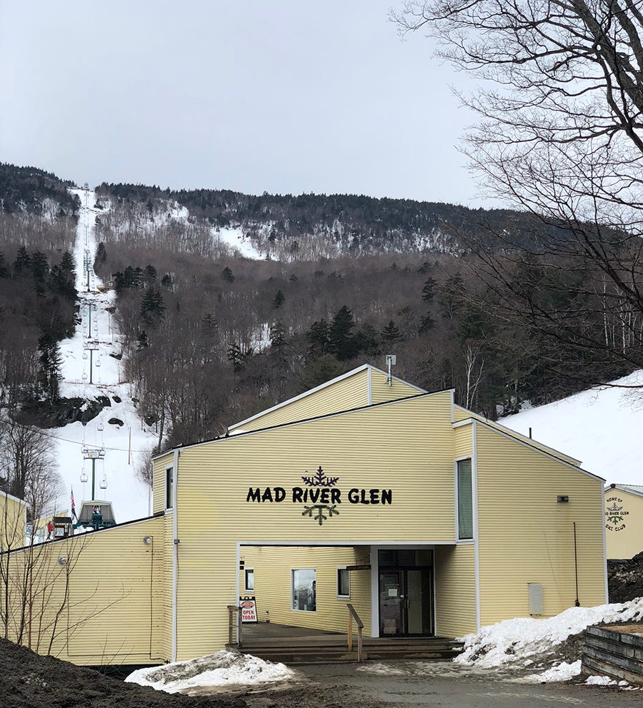 Mad River Mountain in USA: a yellow building with a ski lift in the background.