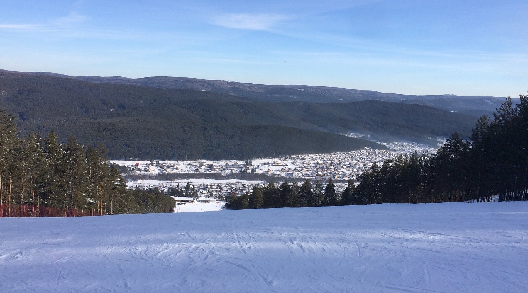 A winter sports scene at Mratkino in Beloretsk Russia featuring a ski resort with a challet a buzzing winter sports centre and snow-covered slopes ideal for skiing.