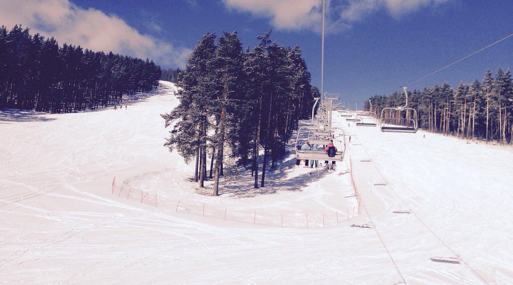 Winter scene at Mratkino, Beloretsk, showcasing a bustling ski resort, dotted with charming chalets, and a ski lift leading to the snowy slopes, awaiting sports enthusiasts.