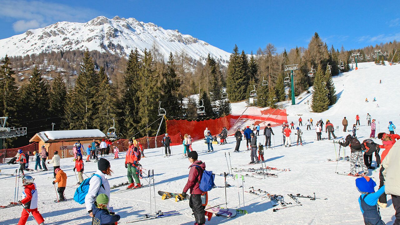 Alpe Lusia – Moena | Bellamonte in Italy - a group of people skiing down a snow covered slope.