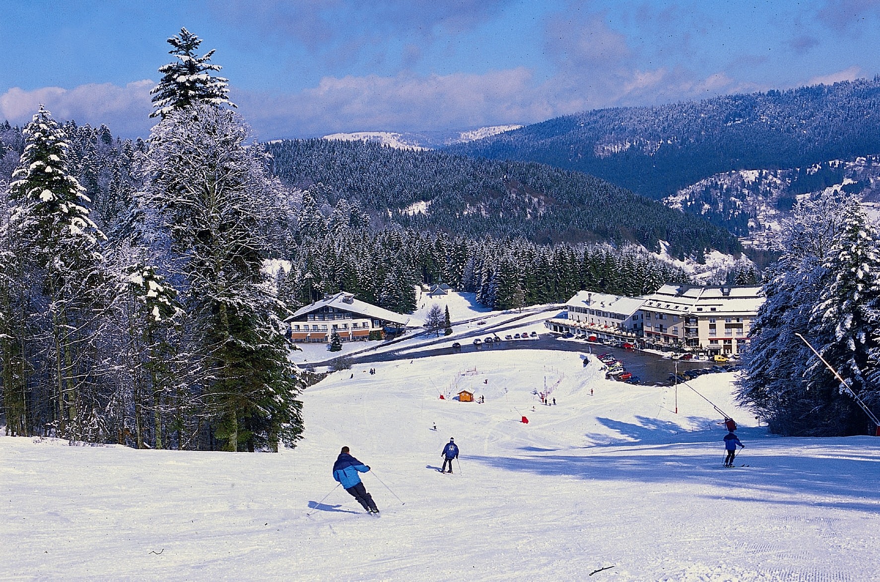 A winter sports scene at Ventron ski resort in France featuring a ski lift and chalet amidst the snowy landscape of the Vosges mountains in Grand-Est region.