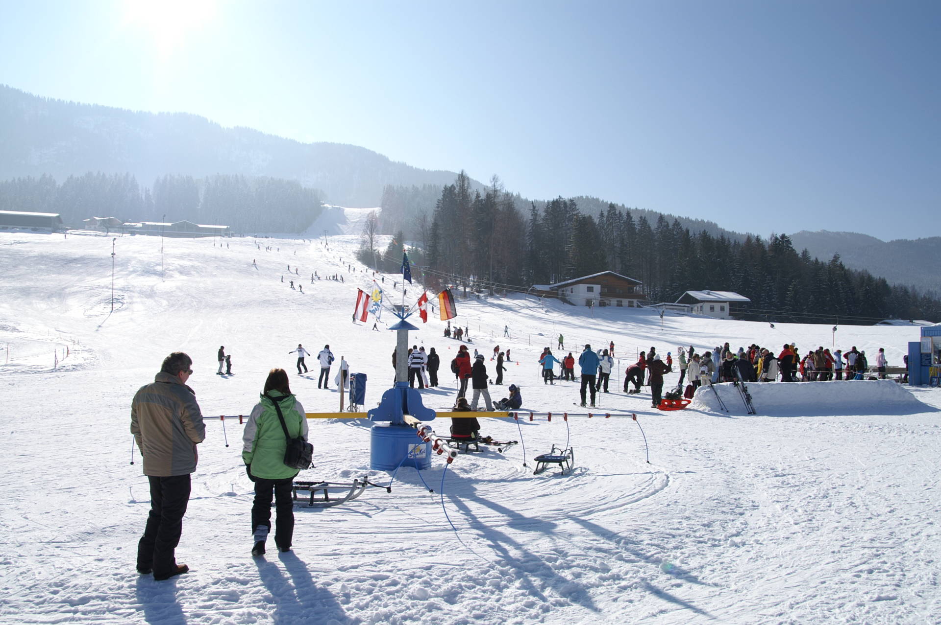 Winter sports enthusiasts enjoying their day at Schneeberglifte – Mitterland ski resort in Tyrol, Austria, featuring a charming chalet amidst stunning snowy scenery.