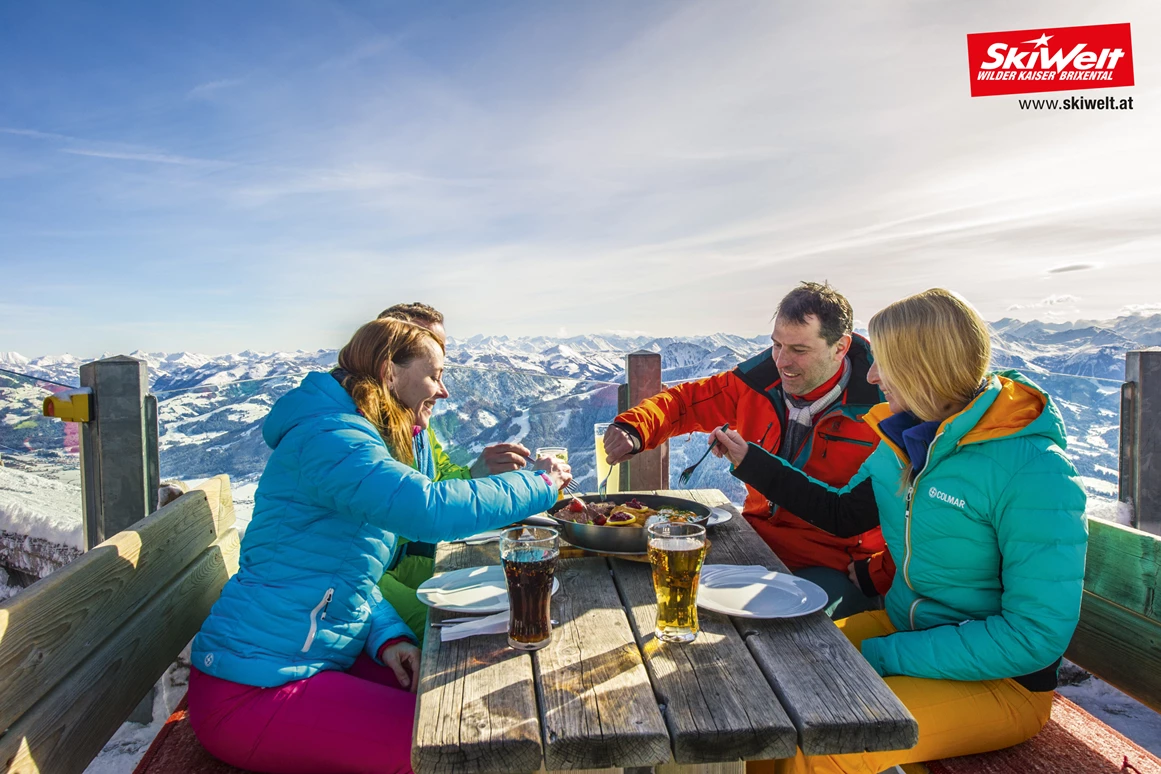 Schneeberglifte – Mitterland in Austria - a group of people sitting at a table in the snow.