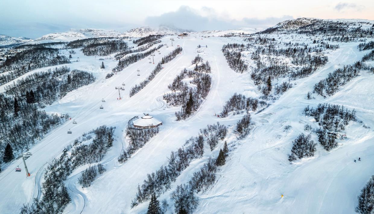 Raudalen in Norway - a ski slope covered in snow with trees in the background.