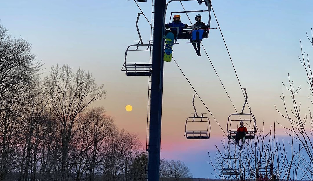 A picturesque view at Mount Pleasant of Edinboro in Cambridge Springs PA with a ski lift active skiers and a challet adding charm to the winter sports scene at this ski resort.