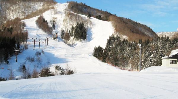 A winter scene at St Mary's ski resort in Tōhoku Japan showing snow-covered slopes a ski lift and a challet promoting a vibrant locale for winter sports.