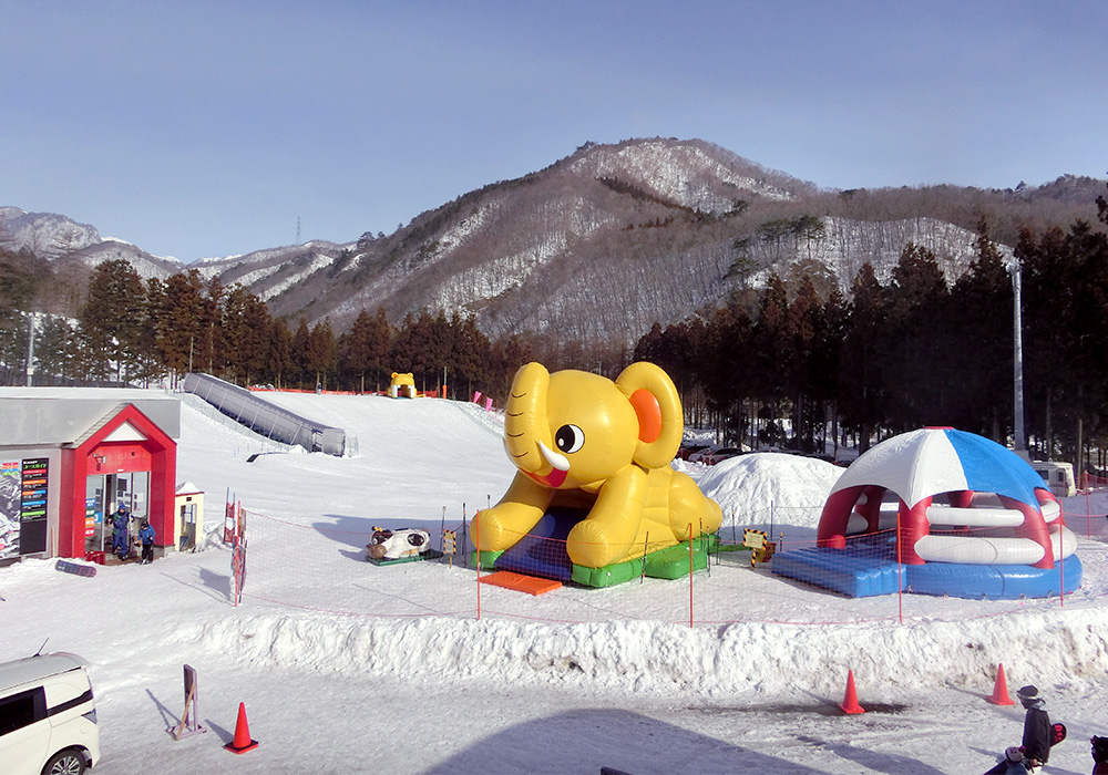 A snowboarder and skier enjoying winter sports at St Mary in Tōhoku, Japan. The snowy terrain encapsulates the vibrant atmosphere of a ski resort and winter sports center.