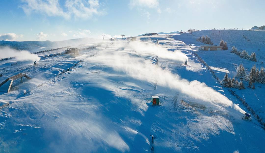 Scenic view of the Weinebene winter sports scene in Lower Carinthia, Austria, featuring a bustling ski resort, charming snow-covered slopes and a breathtaking winter landscape.