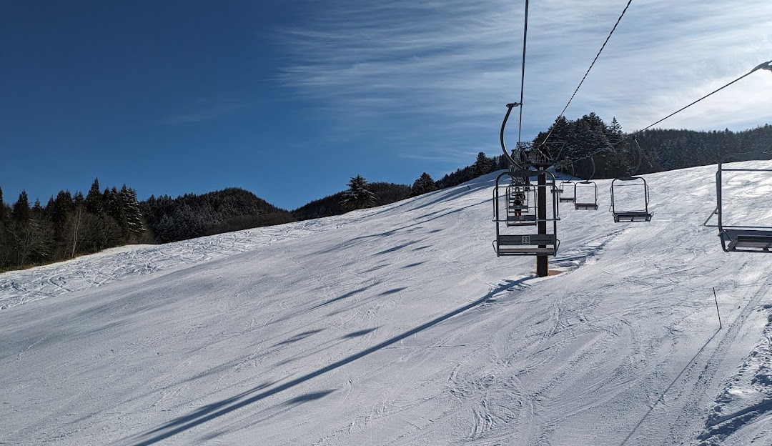A winter scene at Hida Takayama ski resort in Japan featuring a ski lift ski resort a glimpse of a challet a skier in action creating a vibrant winter sports atmosphere.