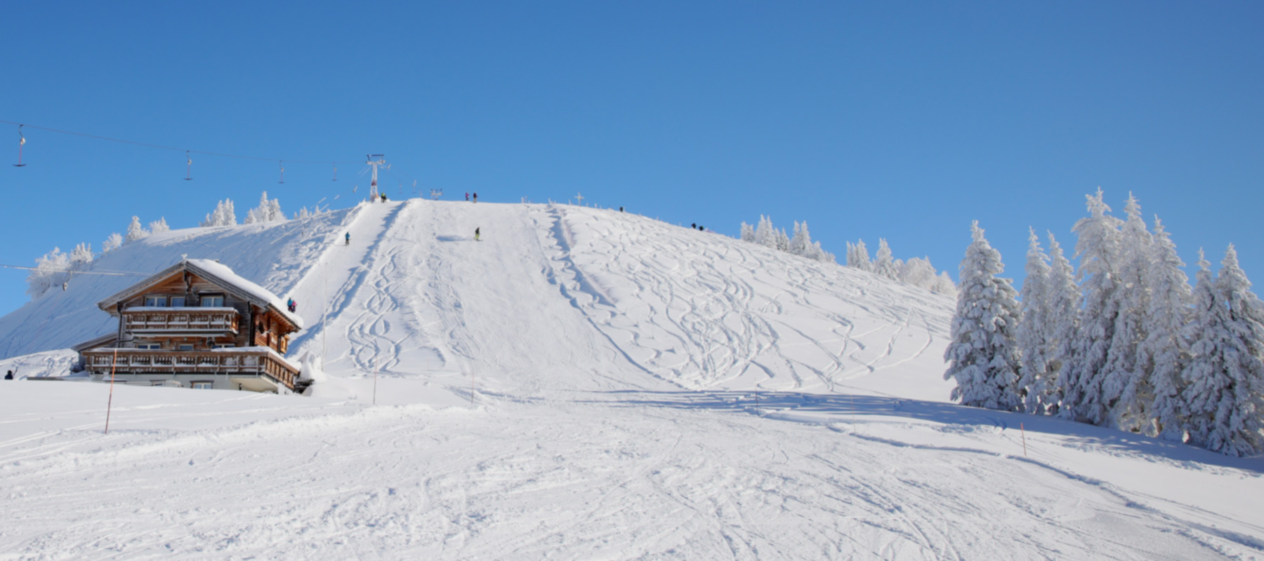 A skier enjoying a winter sports scene at the Eggberge ski resort in Altdorf Switzerland. Snow-covered slopes and a ski lift add to the idyllic winter setting.