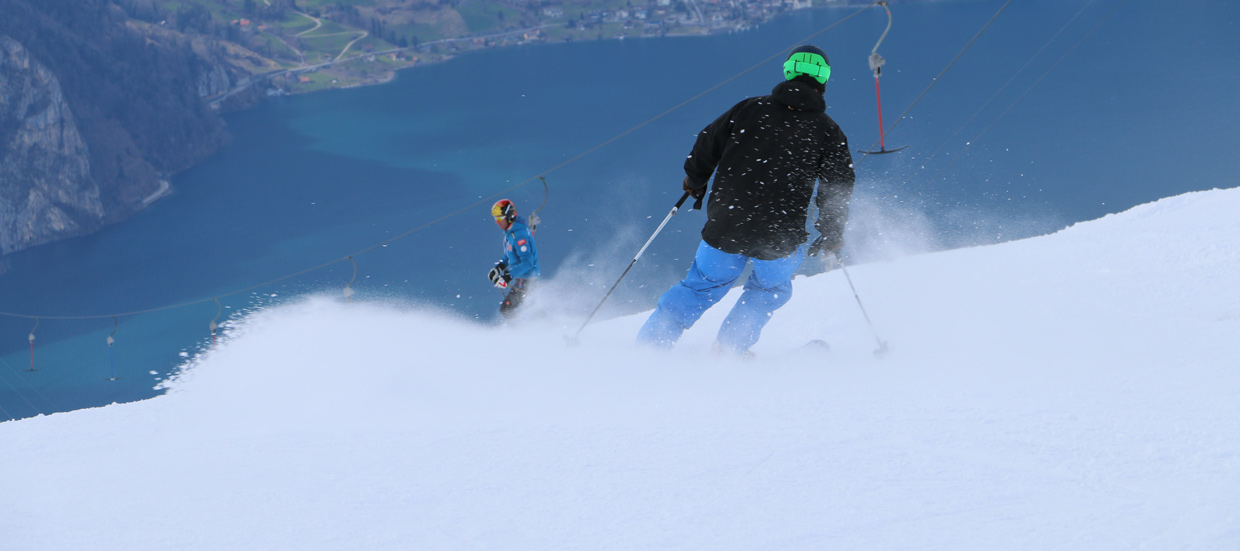 A skier at Eggberge in Uri Switzerland with a winter sports scene in the backdrop featuring a ski lift. The setting is in Altdorf a ski resort in Central Switzerland.
