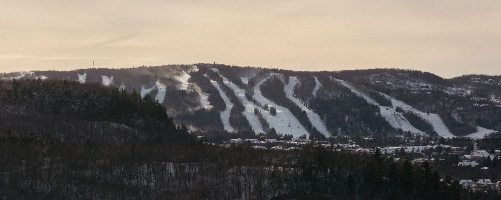 Sommet Gabriel in Canada - a mountain covered in snow with trees in the fore.
