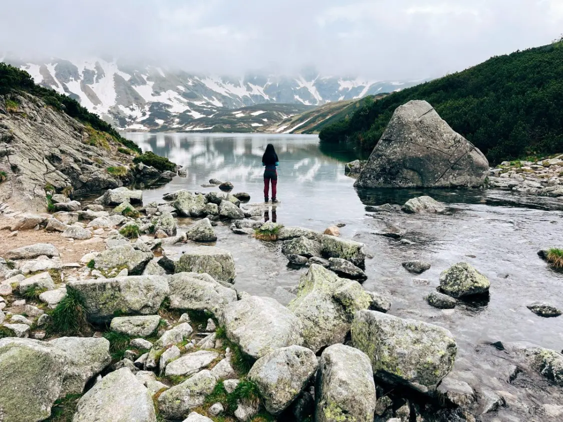 Palenica in Poland - a person standing on rocks near a body of water.