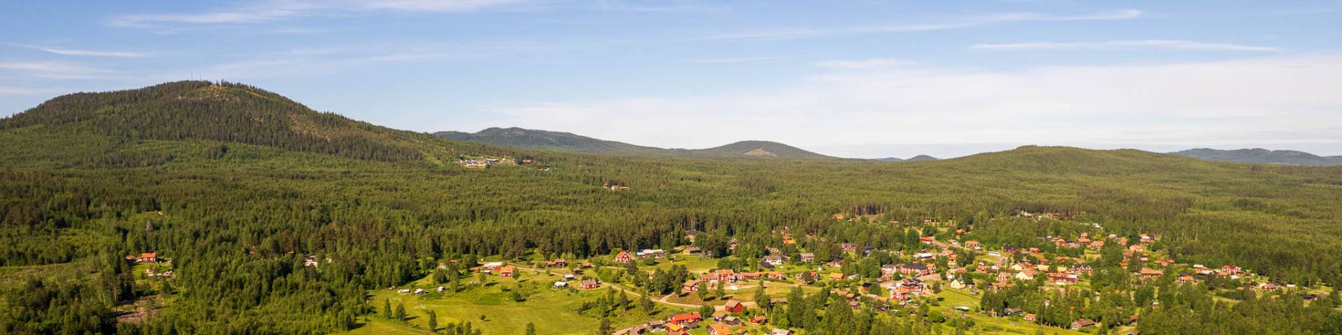 Picturesque chalet at the Gesundaberget ski resort in Sollerön, Central Sweden. The building sits nestled in a mountain environment, bathed in the warm glow of a sunny day.