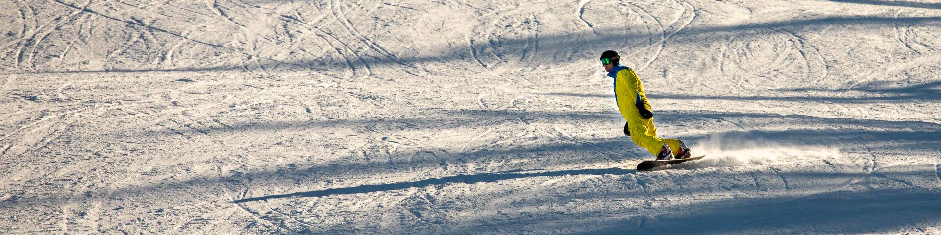 A charming chalet nestled in the snow-covered landscape of Gesundaberget Sollerön Central Sweden. The scene showcases the beauty of winter sports activities with the presence of a snowmobile subtly visible.