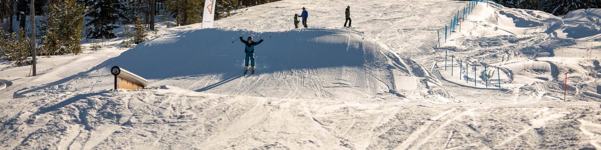 A skier and a snowboarder traverse the snowy slopes of Gesundaberget in Sollerön Sweden highlighting the vibrant winter sports scene. In the background features of a ski resort including a ski lift are subtly present.