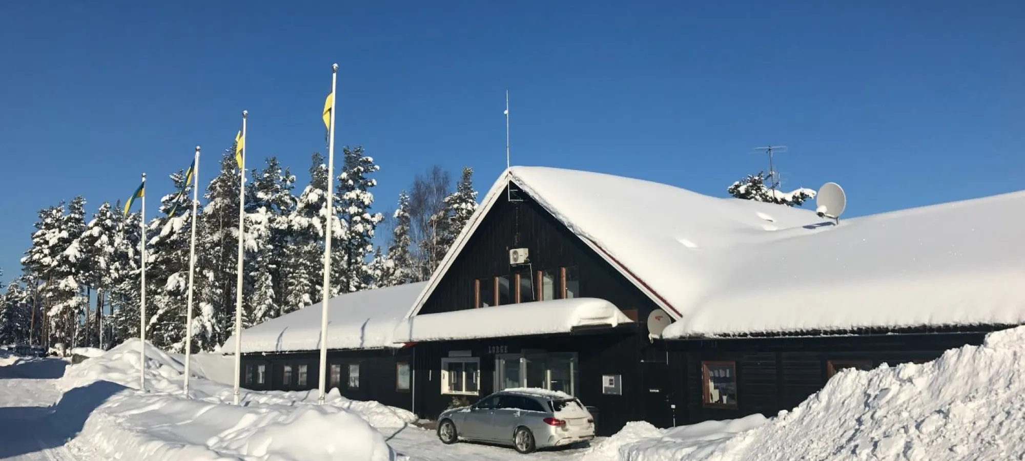 View of Gesundaberget in Sollerön, Central Sweden featuring a bustling winter sports centre with a cozy lodge and active ski resort amidst stunning winter scenery.