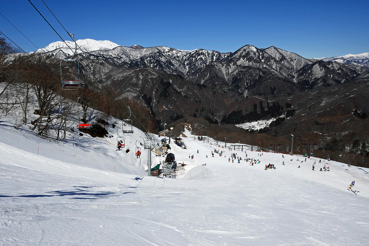 Okutone Snow Park in Japan - a group of people skiing down a snowy slope.
