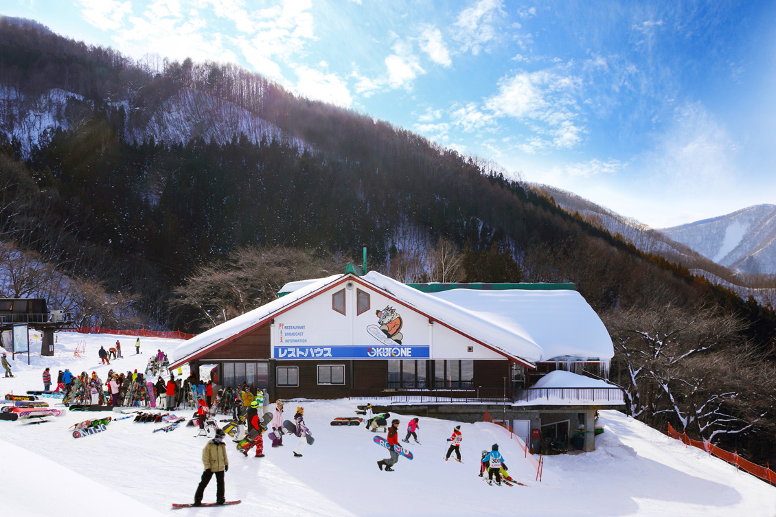 Scenic view of Okutone Snow Park in Japan showcasing a bustling ski resort. Winter sports enthusiasts create a lively scene against the backdrop of stunning winter scenery.