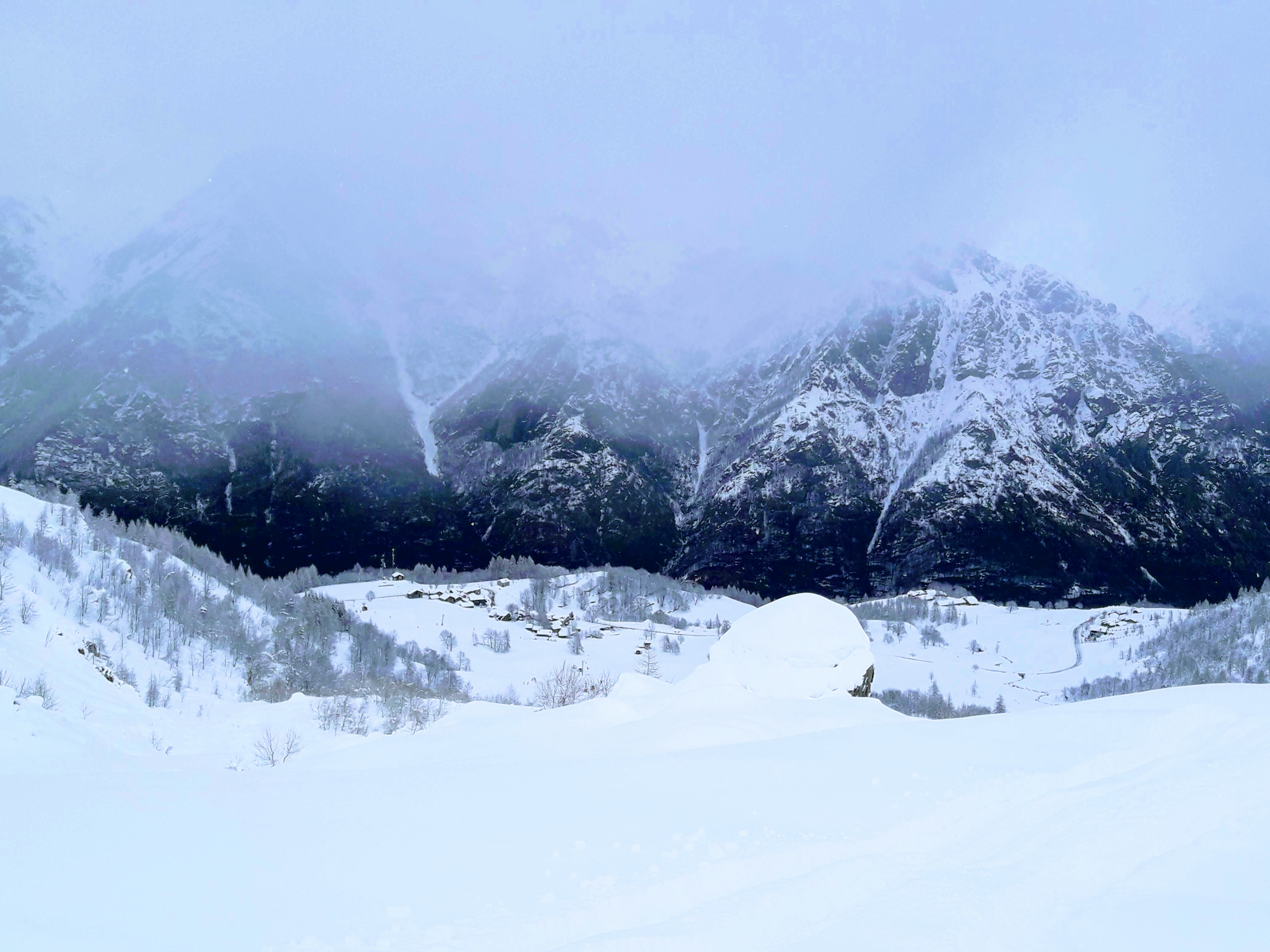 Winter scene at Pian Benot Sciovie Usseglio in Turin, Italy, featuring stunning snow-covered mountains and a quaint chalet, perfect for winter sports activities.