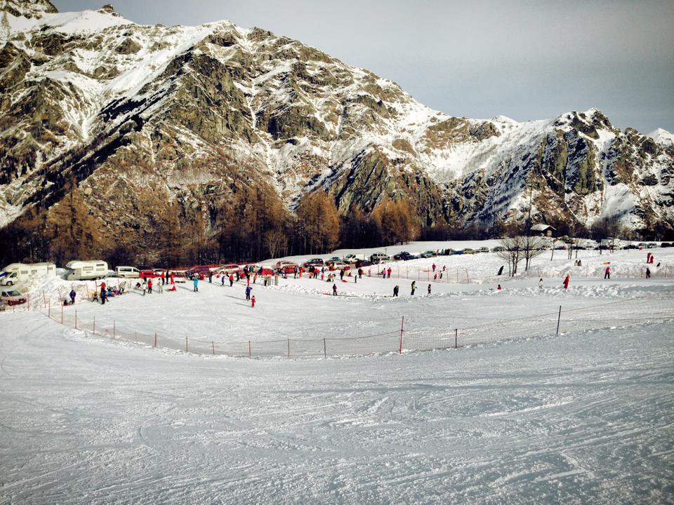 A vibrant winter sports scene at Pian Benot Sciovie Usseglio in Turin Italy showcasing a bustling ski resort a cozy chalet and stunning winter scenery.