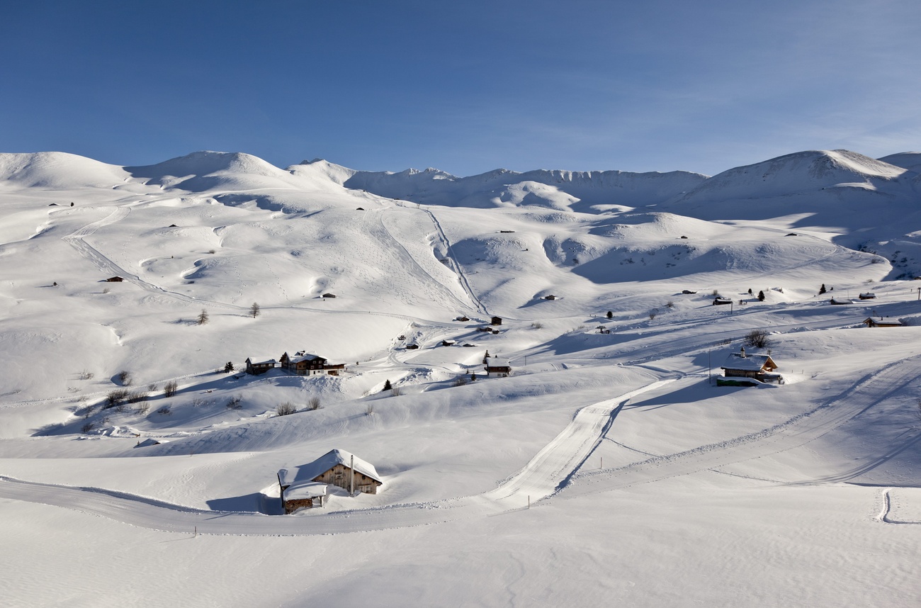 Fideriser Heuberge in Switzerland - a snow covered mountain with a small house in the middle.