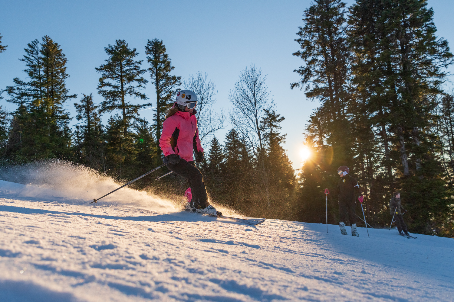 A skier enjoys a winter sports scene at the Terre-Ronde in Ain Plateau d'Hauteville France with families and children learning to ski nearby all surrounded by the picturesque ski resort.