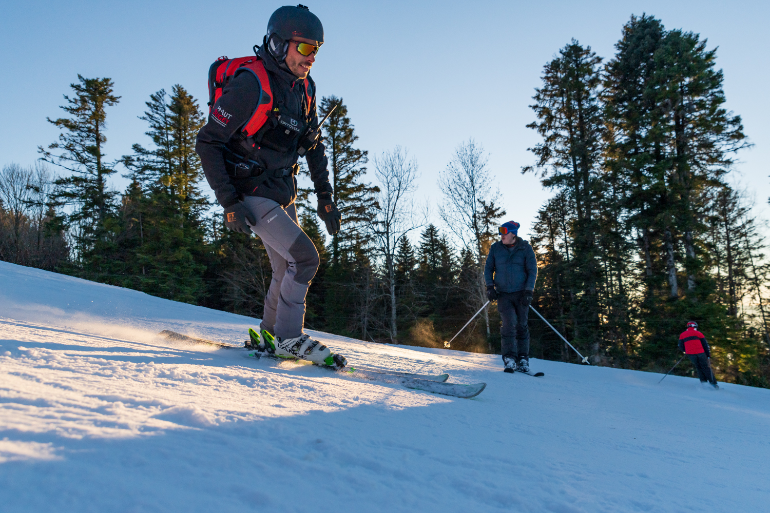 Winter sports scene at Terre-Ronde, France featuring a skier and groups enjoying skiing and snowboarding in the snowy landscape.