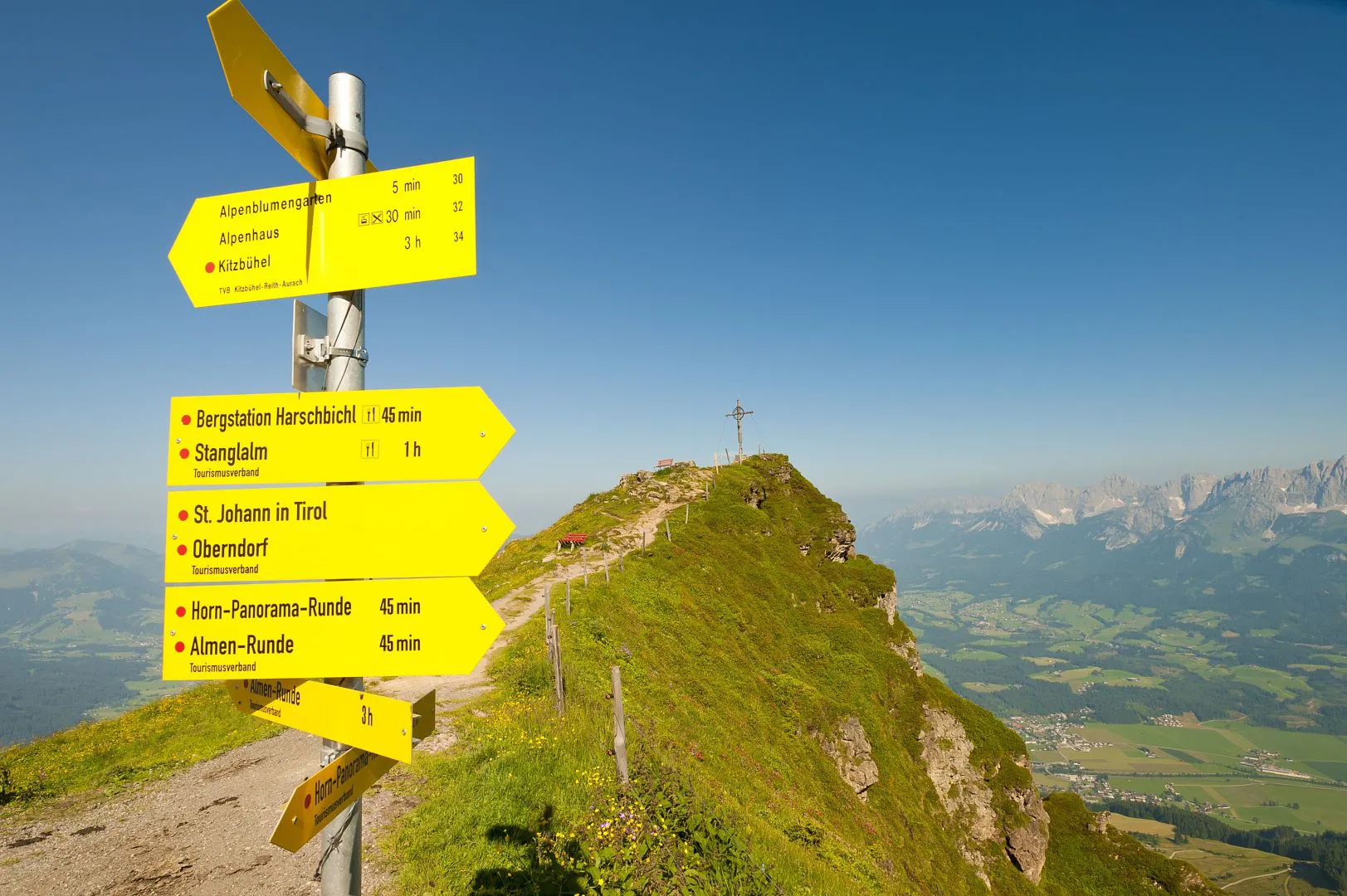 St Johann in Tirol | ​Oberndorf – Harschbichl in Austria - a yellow sign sitting on top of a mountain.