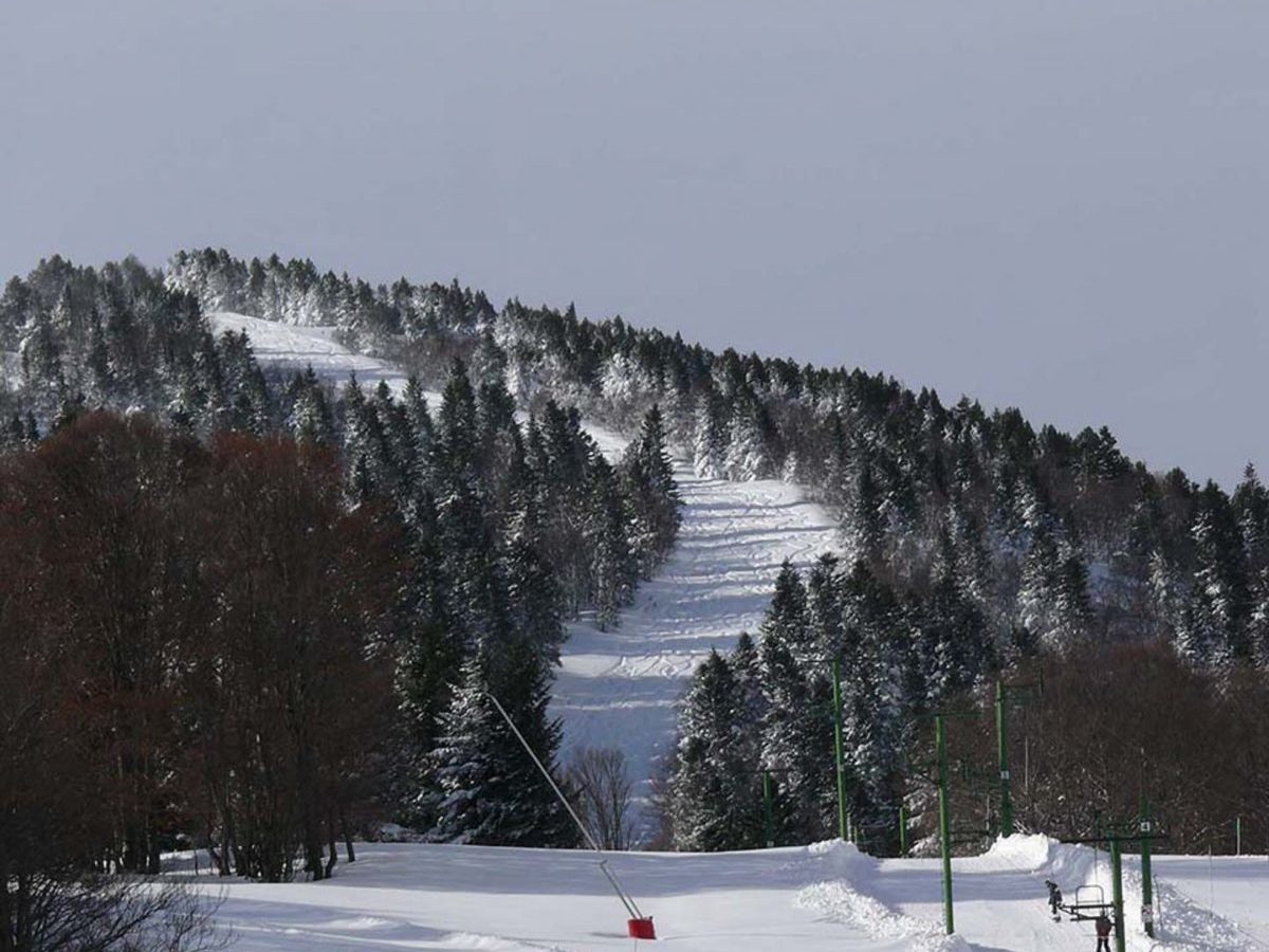 Mijanès-Donezan in France - a snow covered ski slope with trees in the background.