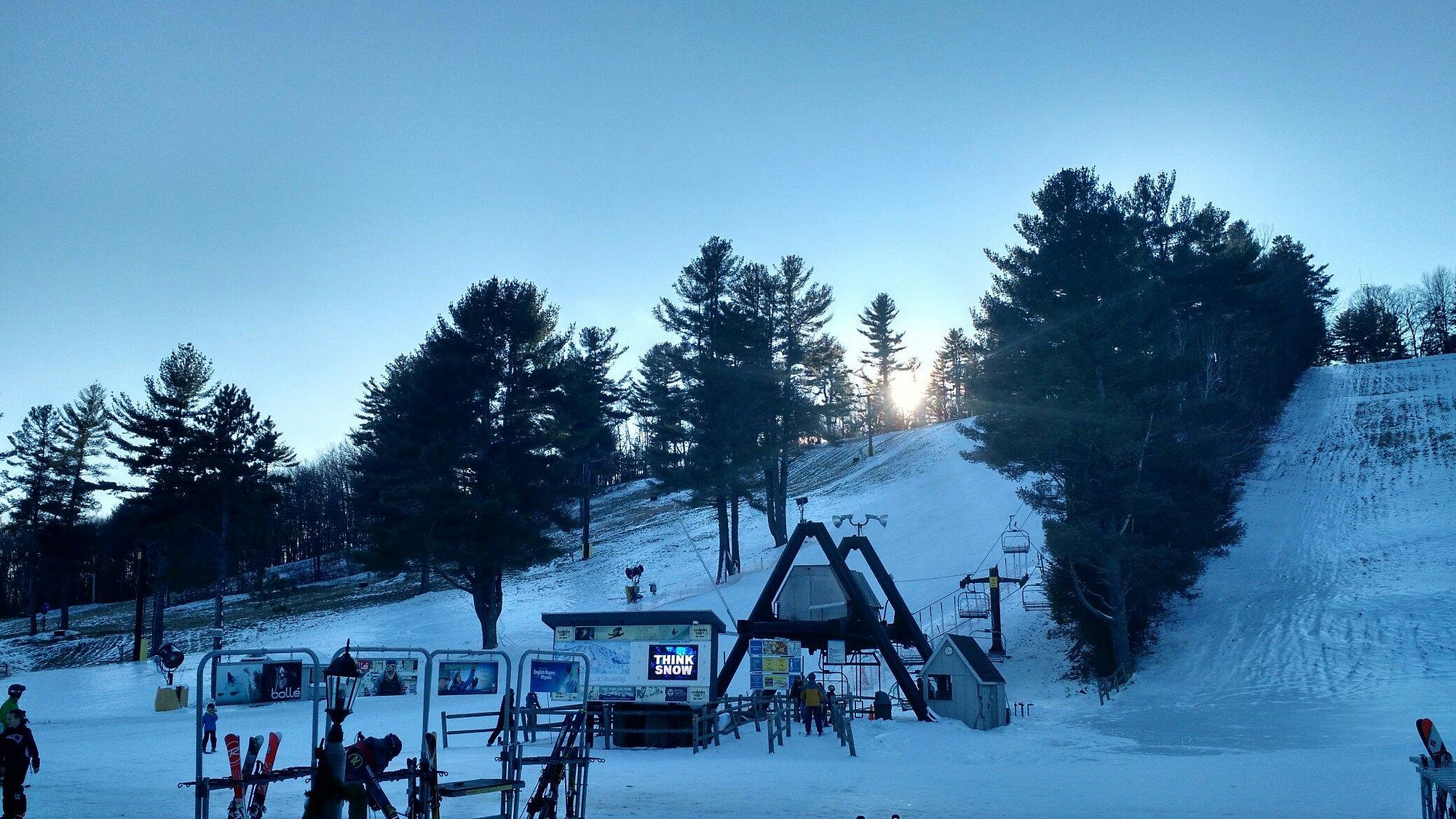 Skiers ready to descend on snowy slopes at Nashoba Valley Ski Area, Westford, Massachusetts, with ski lifts rising in the background amid a captivating winter landscape.