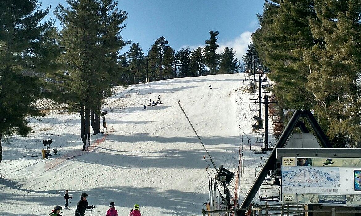 Nashoba Valley Ski Area in USA - a group of people riding ski boards down a hill.