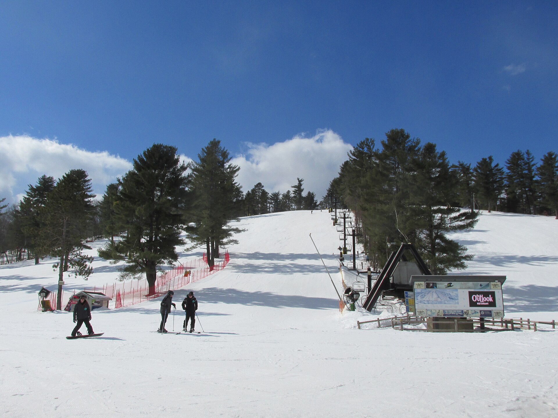 Nashoba Valley Ski Area in USA - a group of people skiing down a snow covered hill.
