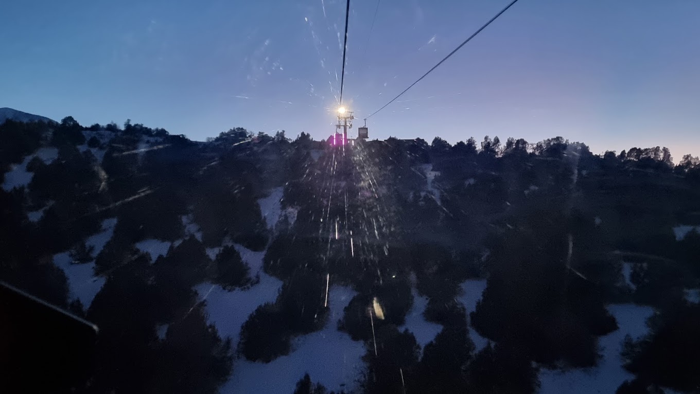 An image showcasing Zomin Ropeway, a ski lift operating in a charming winter landscape in Zomin, Uzbekistan, with hints of a ski resort and chalet in the backdrop.