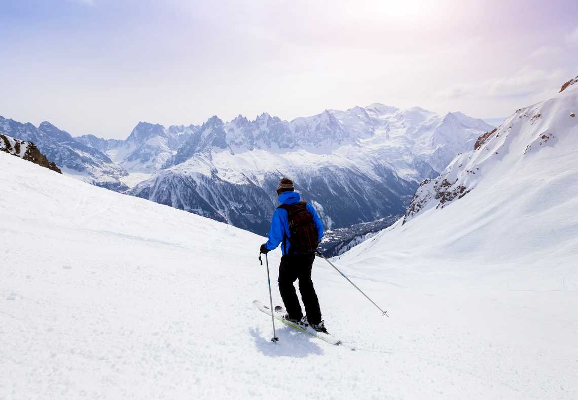 Zomin Ropeway in Uzbekistan - a person skiing down a snowy slope in the mountains.